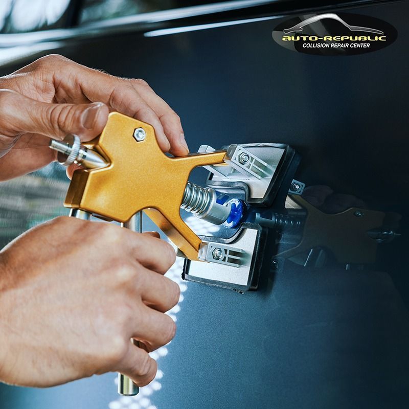 A person is using a tool on a car that says auto republic