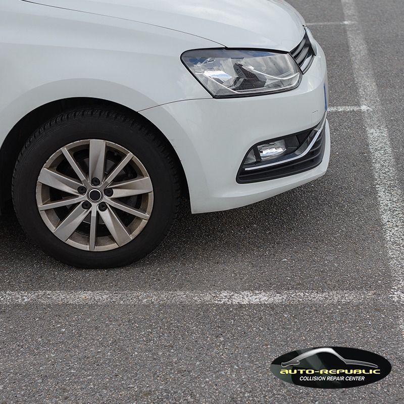 A white car is parked in a parking lot by auto republic