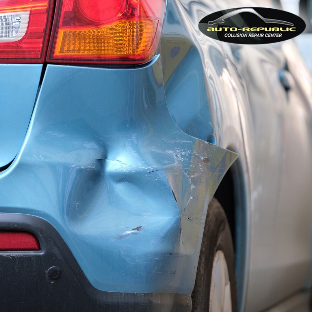 A close up of a blue car with a damaged bumper