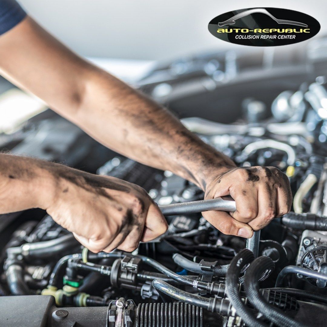A man is working on a car engine with a wrench