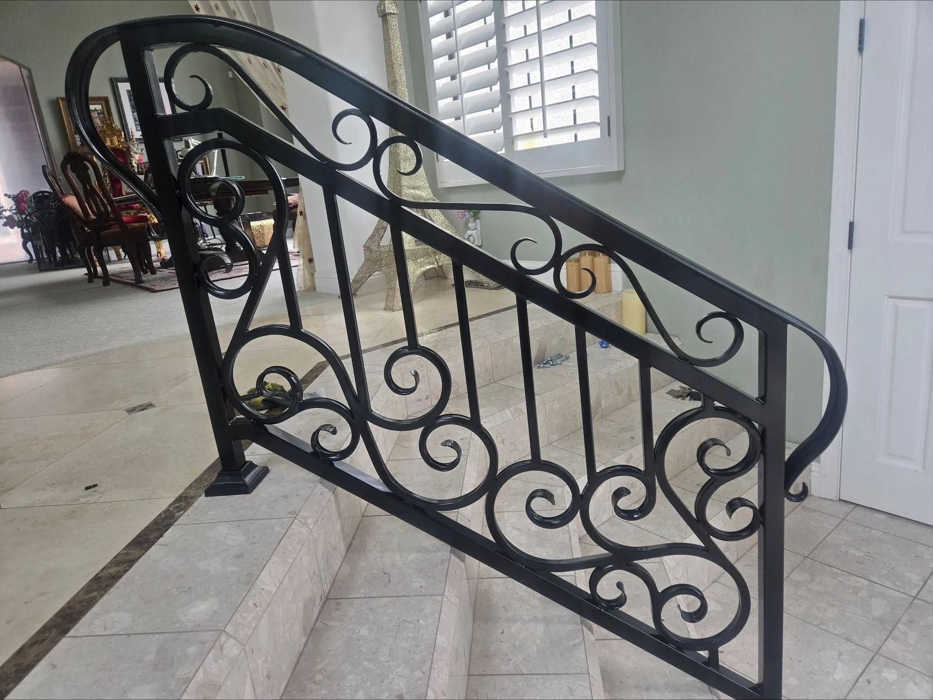 Black wrought iron stair railing with ornate scrollwork.