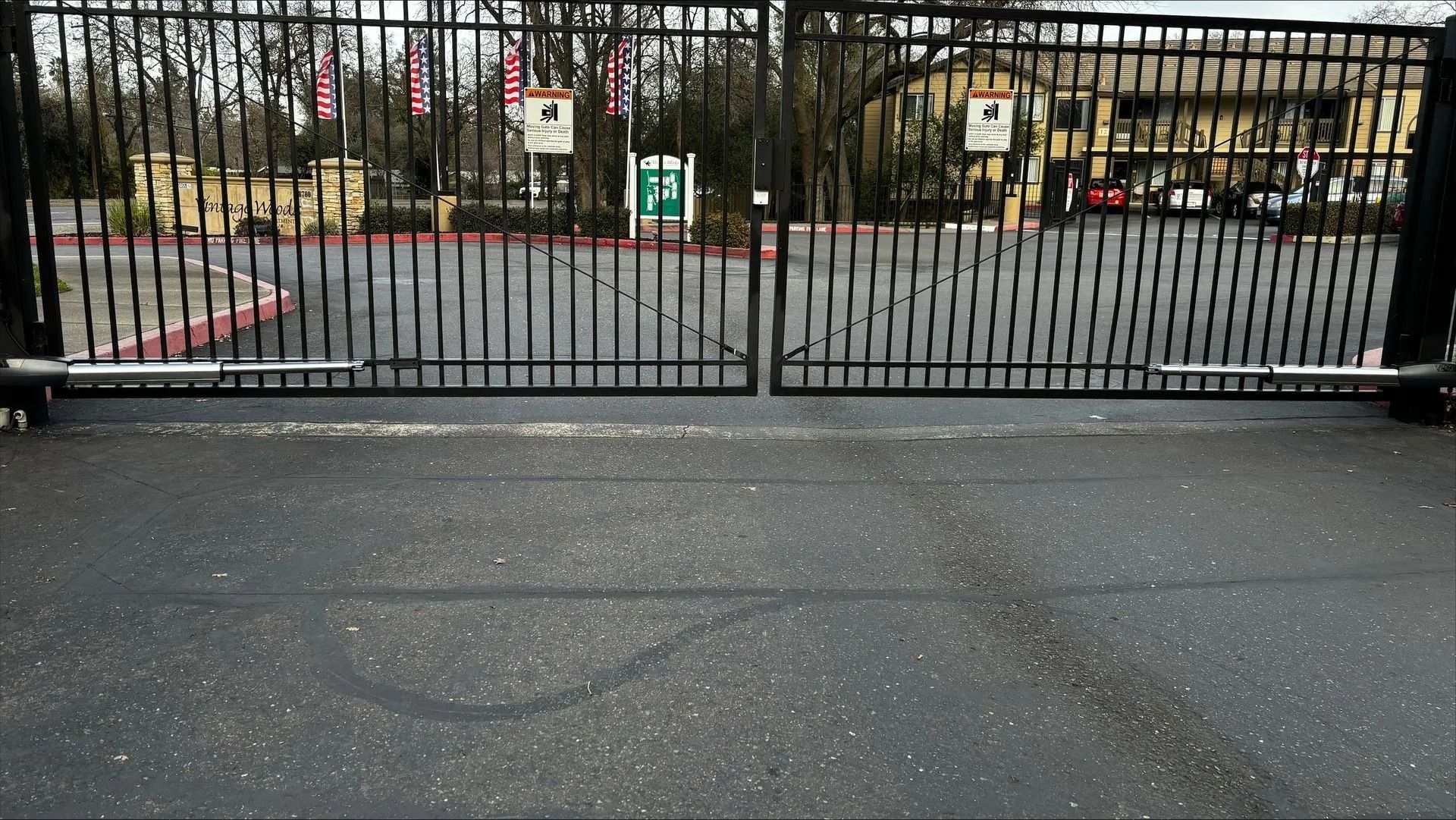 Black metal gated entrance to a building complex.