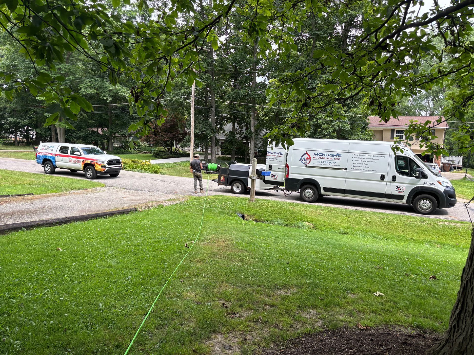 Two service vehicles and trailer on a residential property.