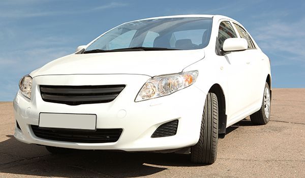 A white car is parked on the side of the road.