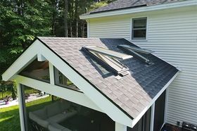 Back of house roof with two skylights and a white gable over a screened porch