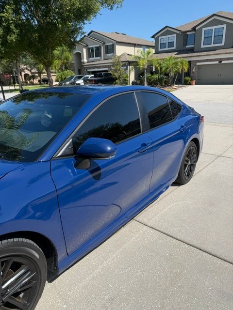 Blue sedan parked in a suburban driveway in front of two-story houses