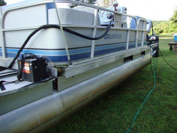 A pontoon boat with a hose attached to it
