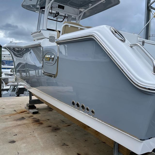 A gray and white boat is sitting on a wooden deck
