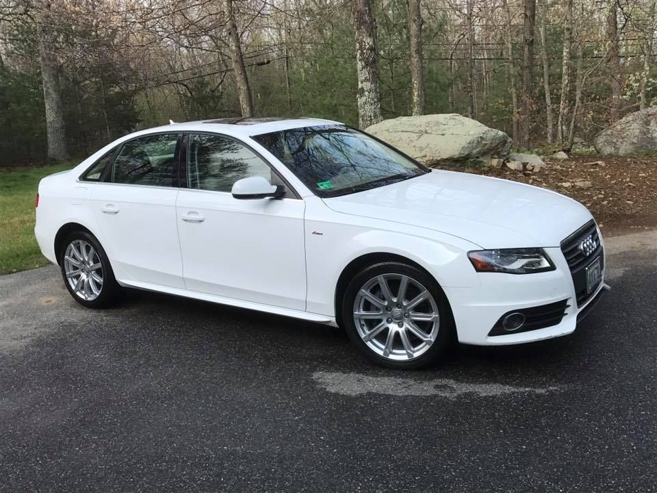 A white audi a4 is parked on the side of the road.