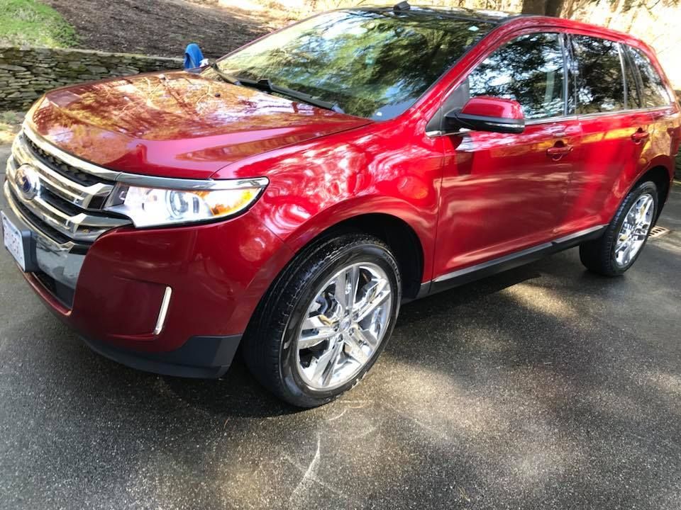 A red ford edge is parked in a driveway.
