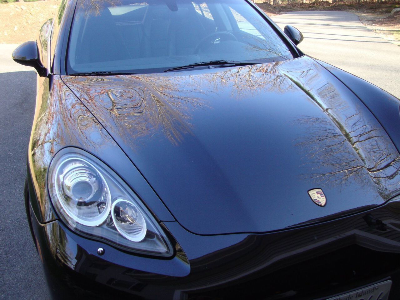 A black porsche is parked on the side of the road