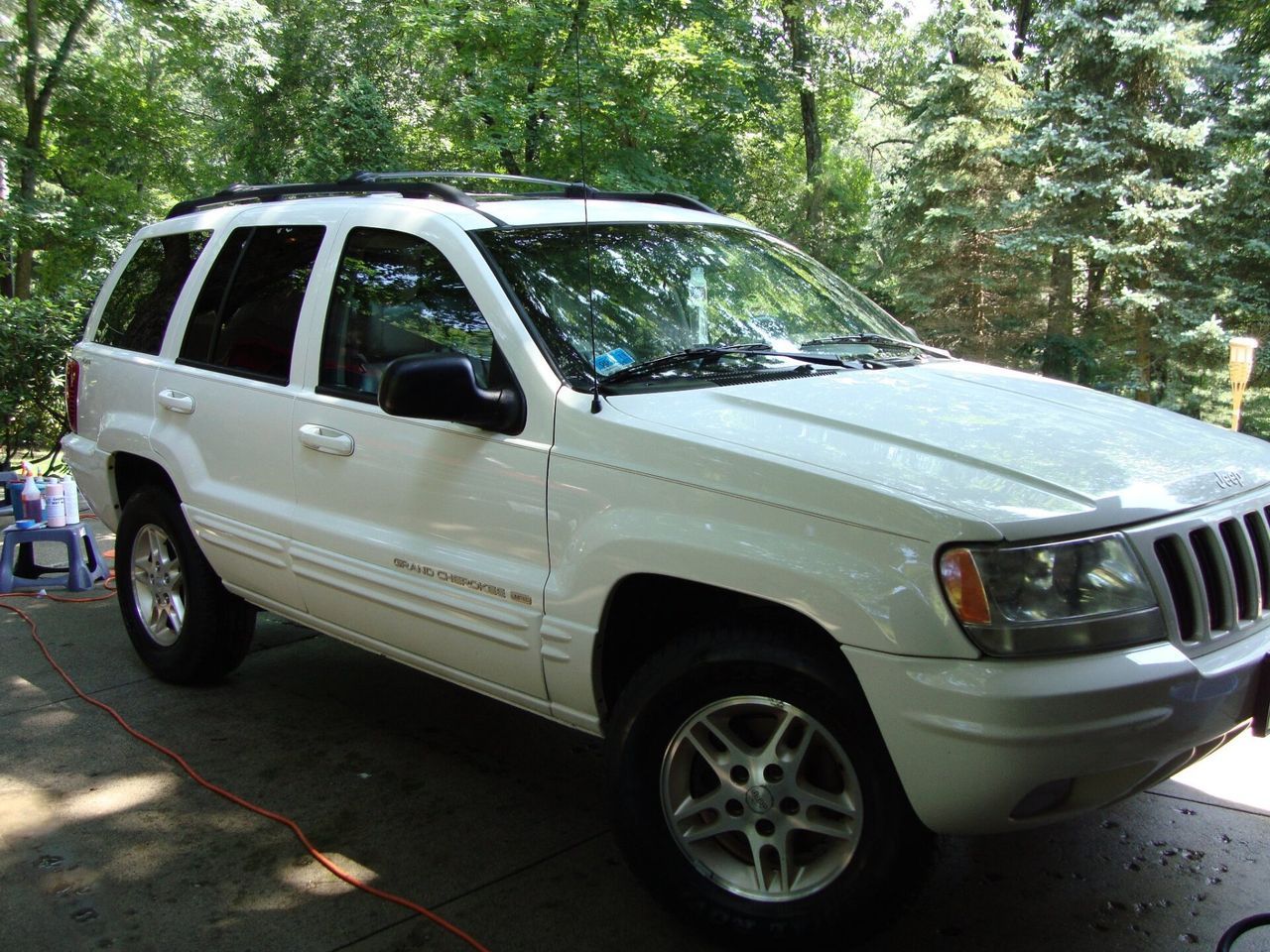 A white jeep grand cherokee is parked in a garage.