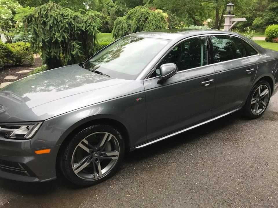 A gray audi a4 is parked in a driveway.