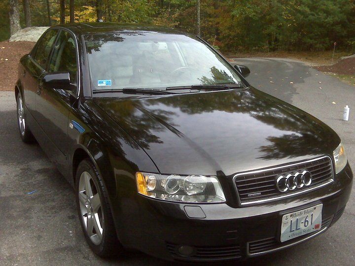 A black audi is parked in a parking lot