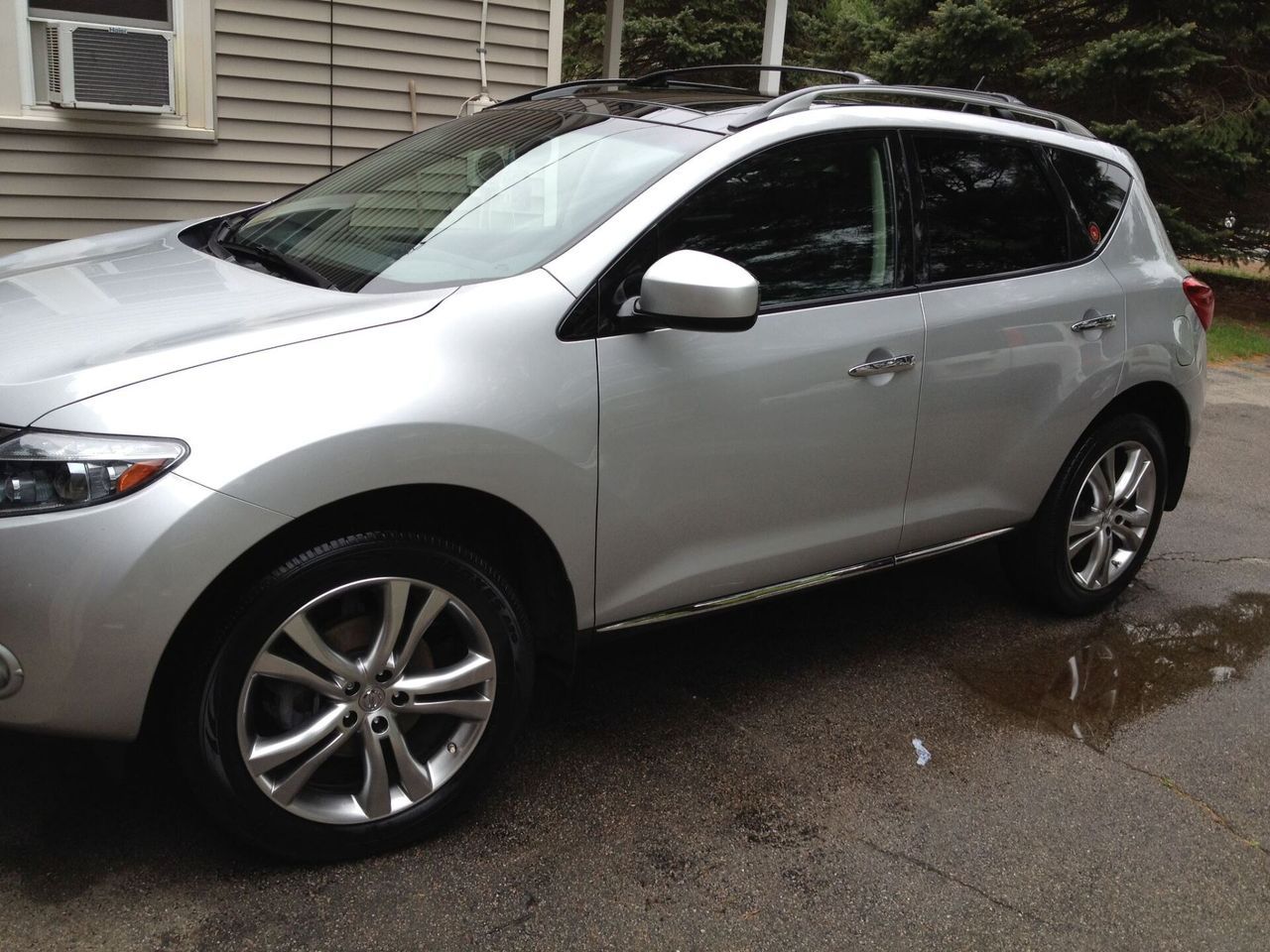 A silver suv is parked in front of a house