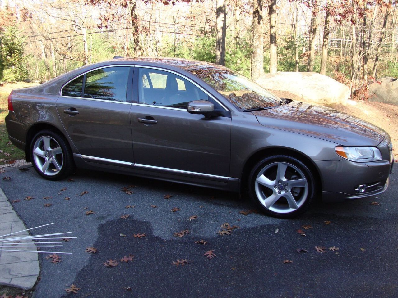 A gray car is parked on the side of the road