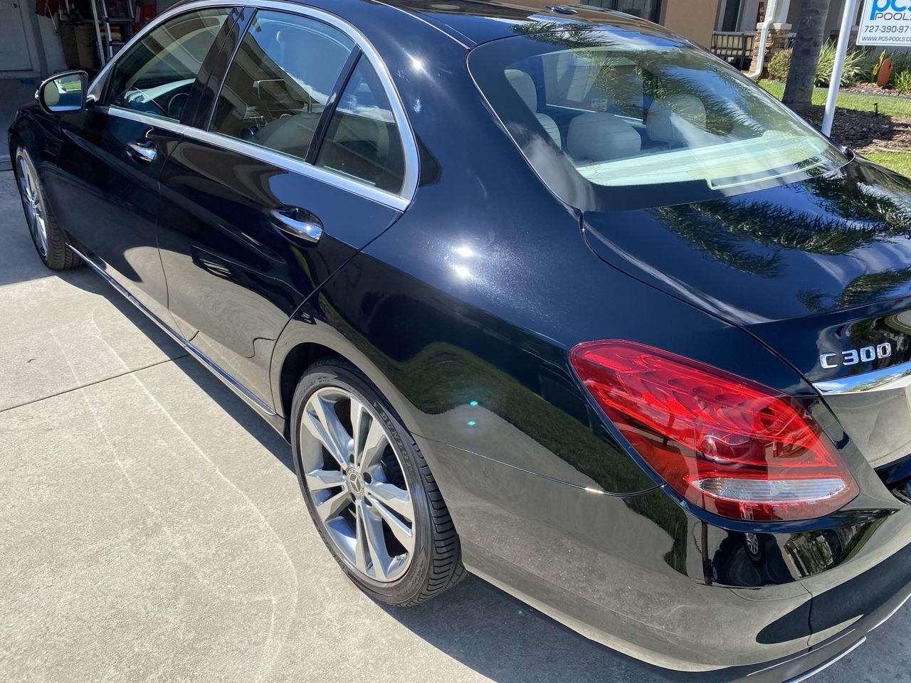 A black mercedes benz c300 is parked in a parking lot.