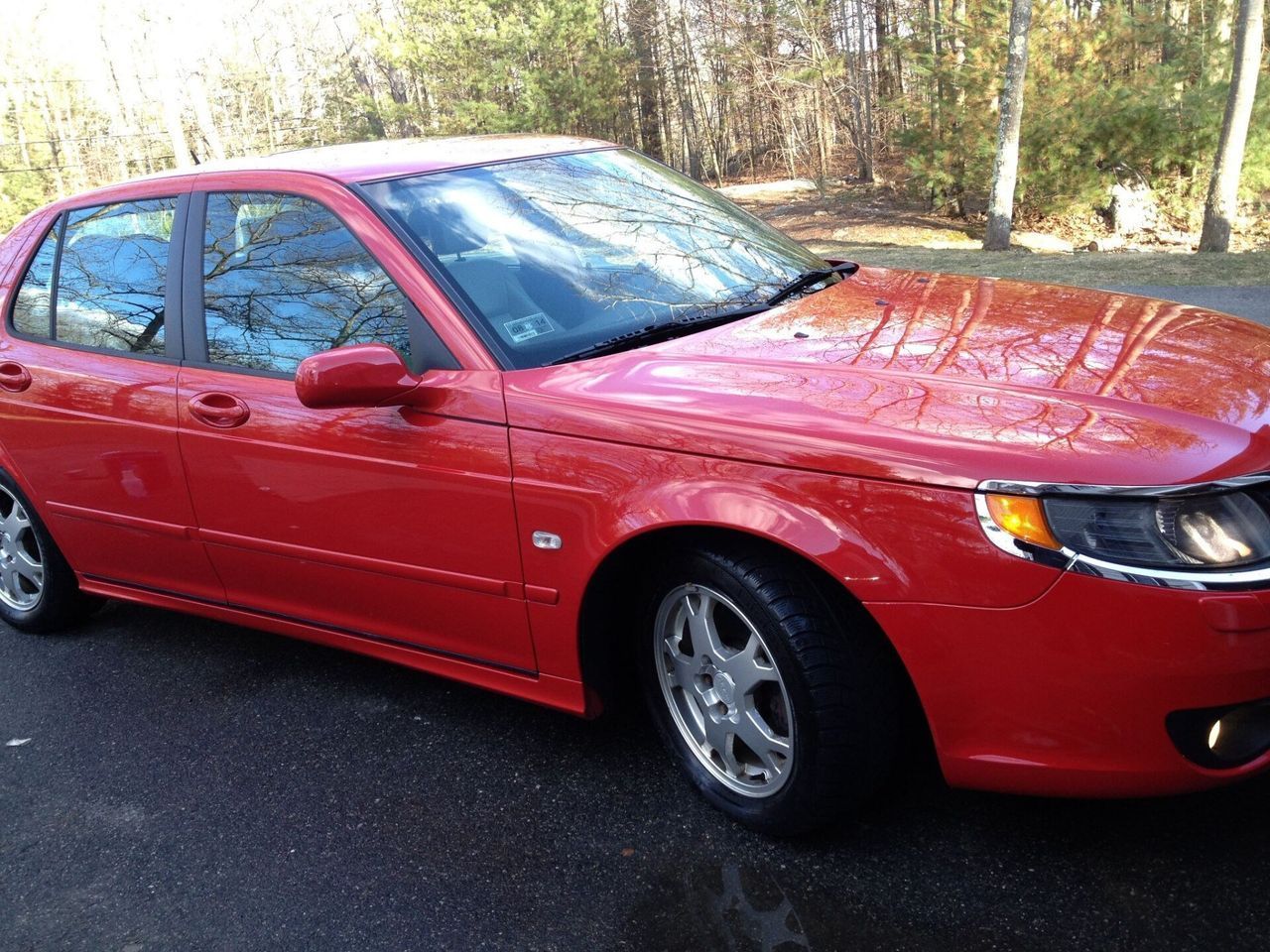 A red car is parked on the side of the road