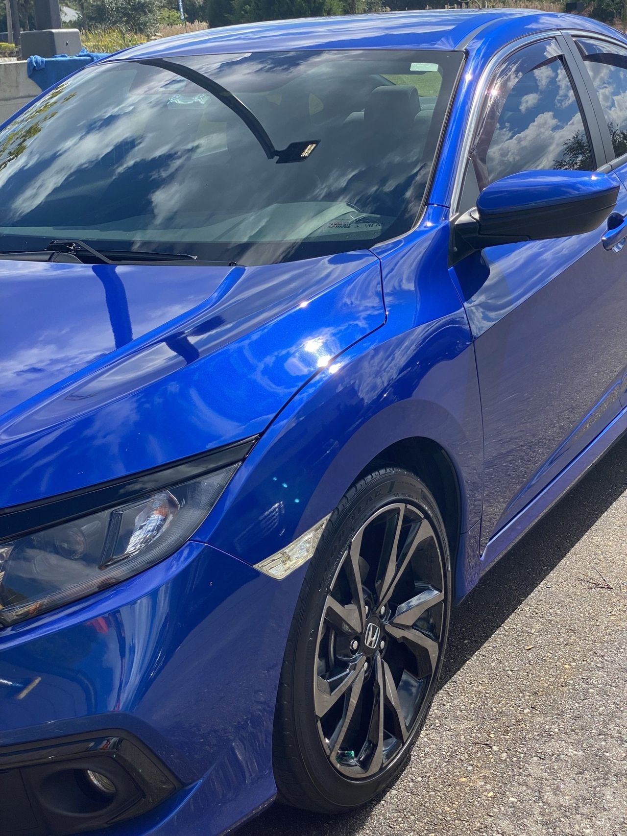 A blue car is parked on the side of the road.