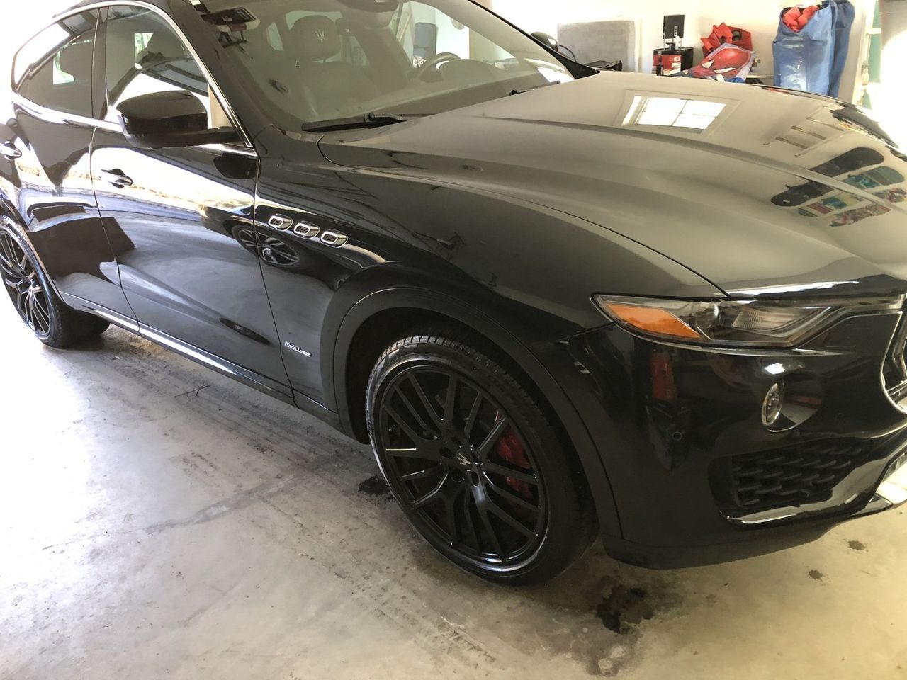 A black car is parked in a garage.