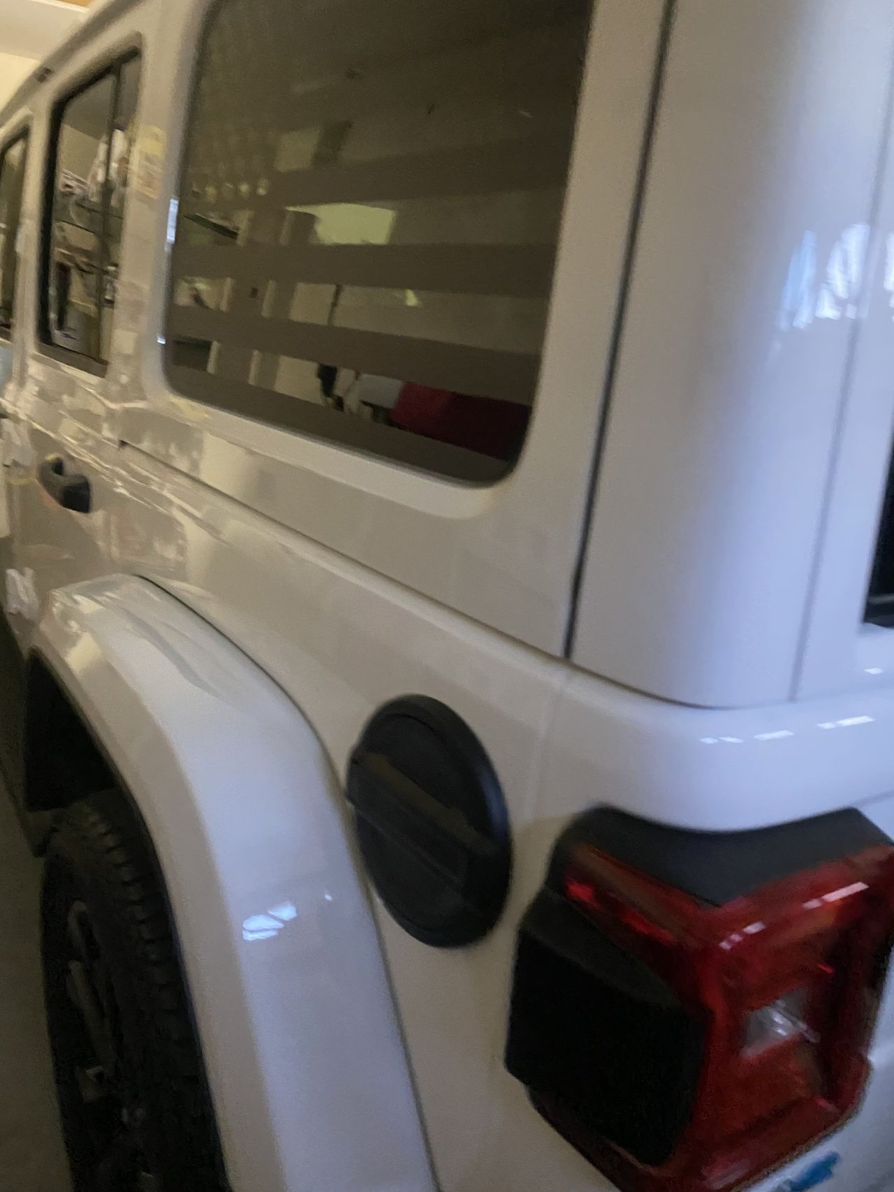 A white jeep is parked in a garage.