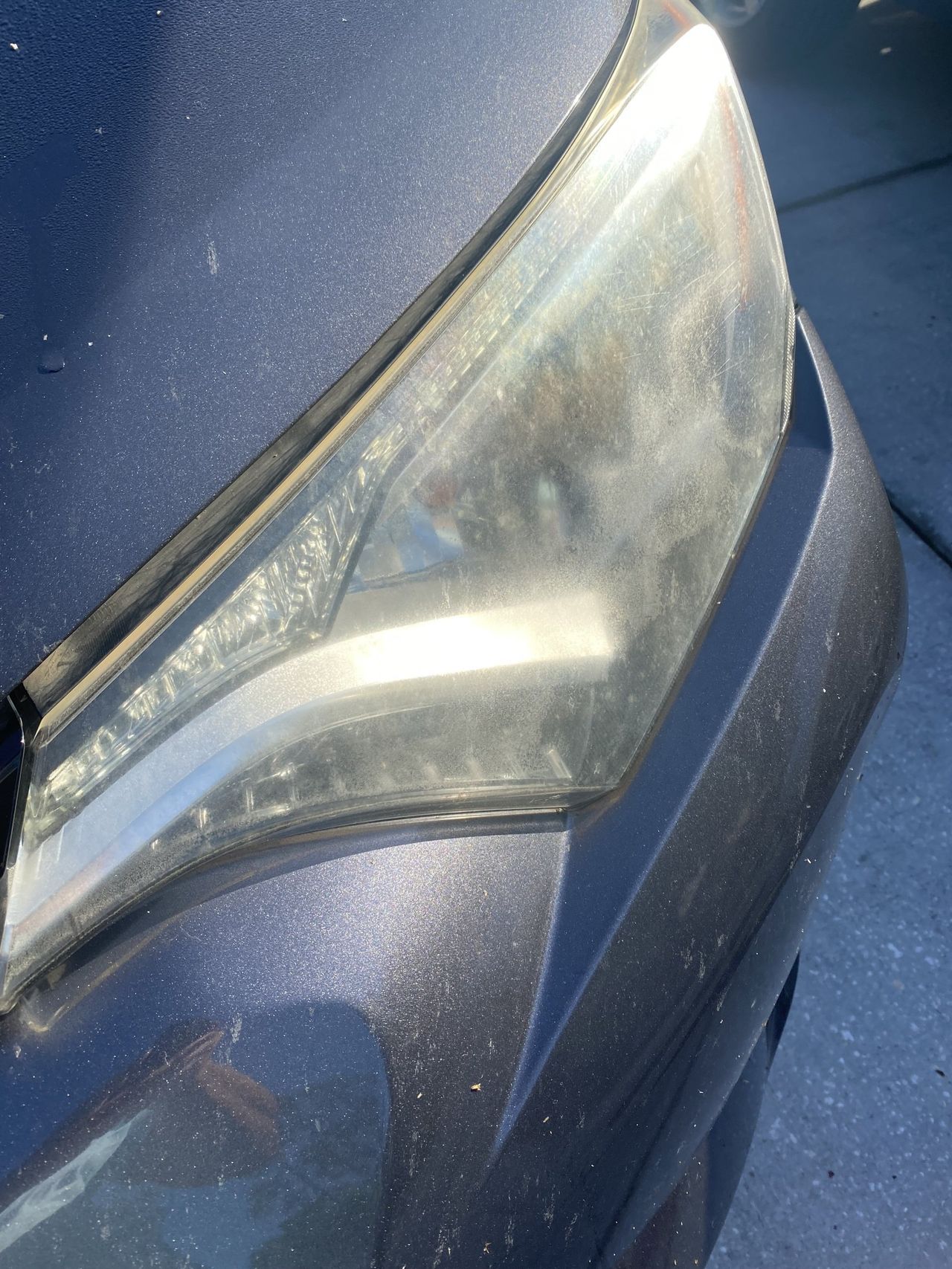 A close up of a dirty headlight on a car