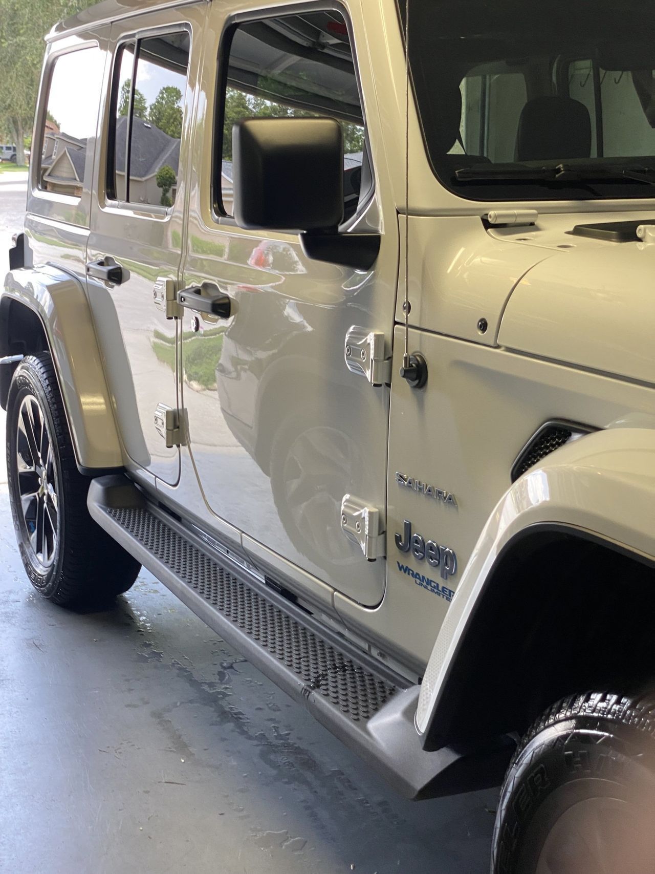 A white jeep is parked in a garage.