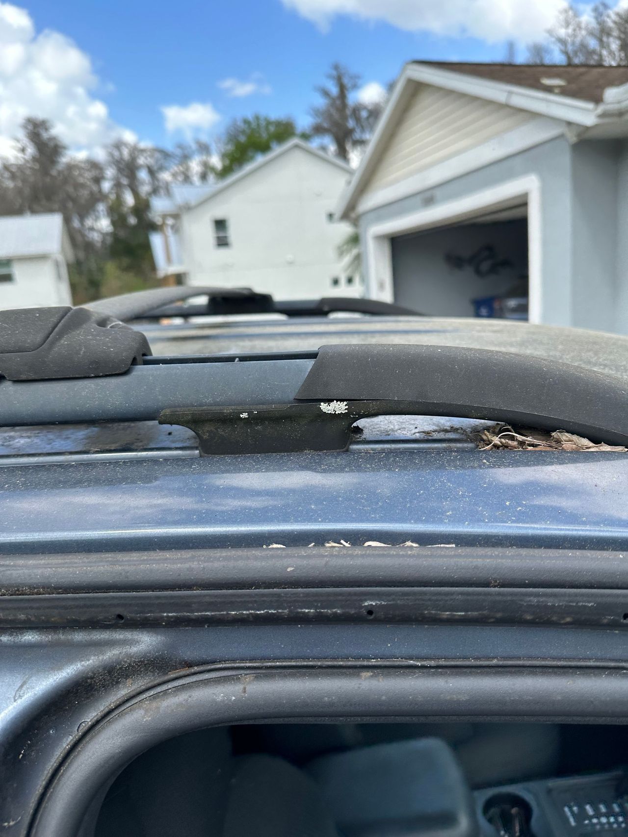 A close up of a roof rack on a car in front of a garage.