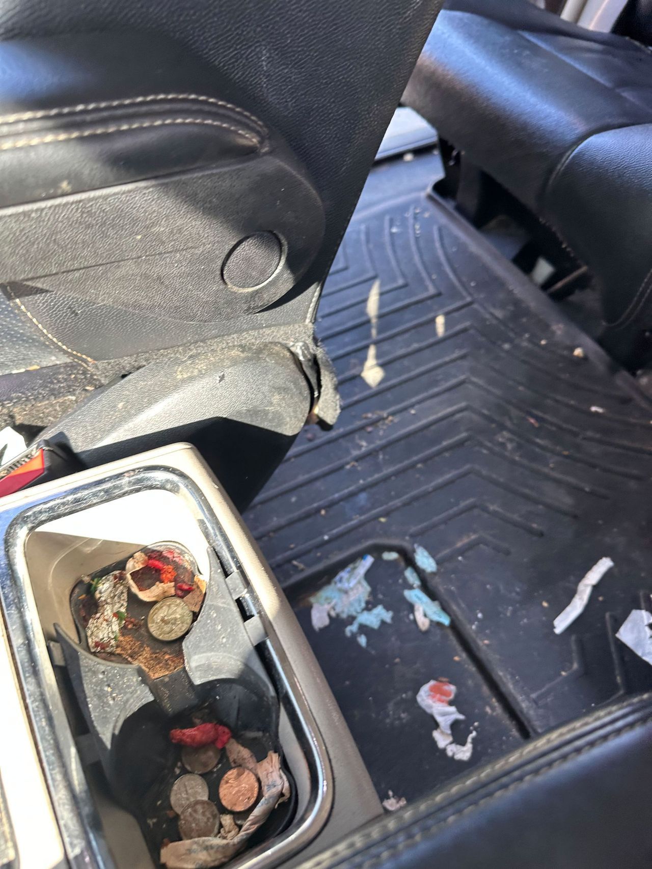 A dirty car with coins in the center console.