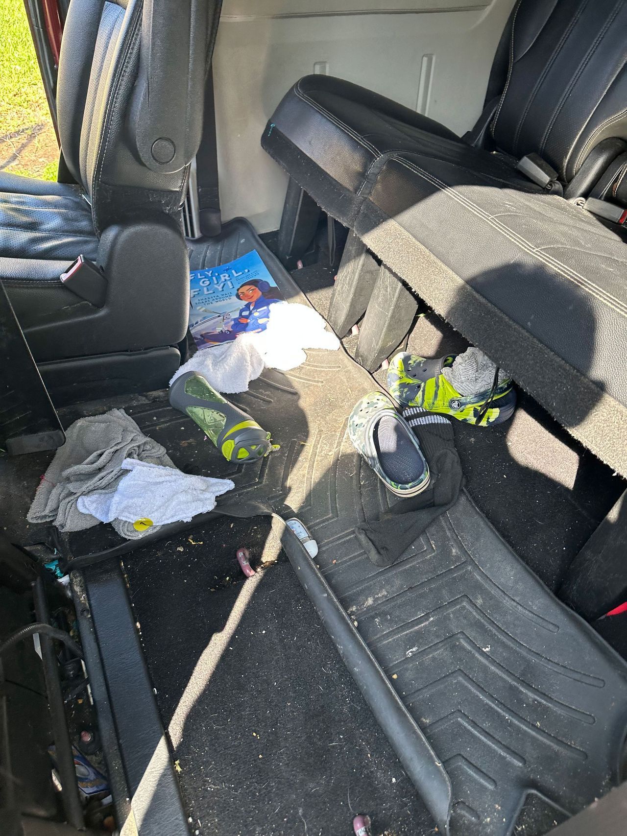 The inside of a car with a lot of trash on the floor.