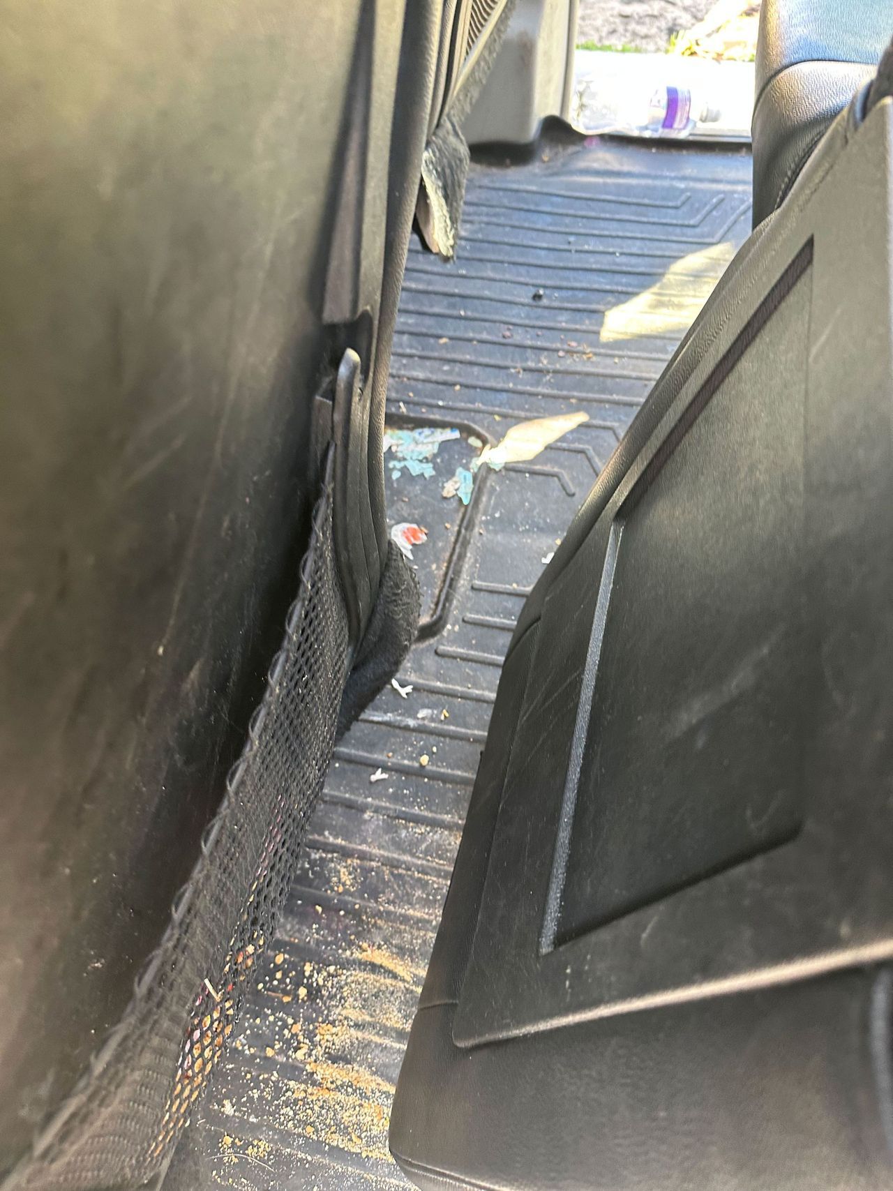 A close up of a dirty floor in a car.