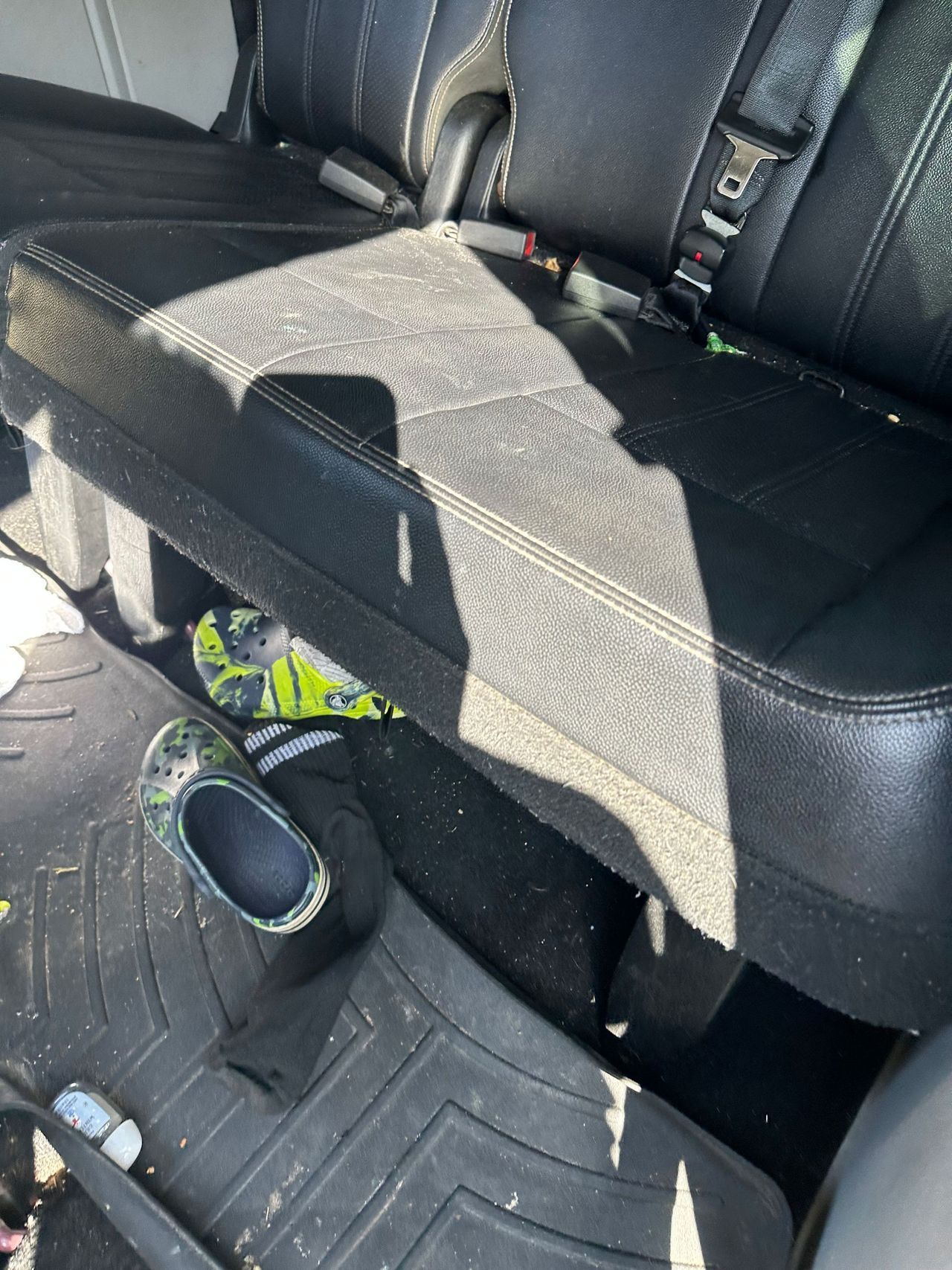 A pair of shoes are sitting in the back seat of a car.