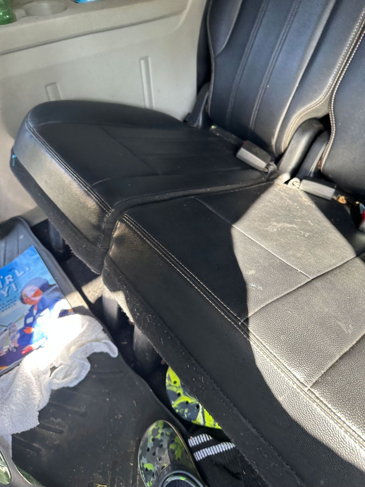 A person is sitting in the back seat of a car.