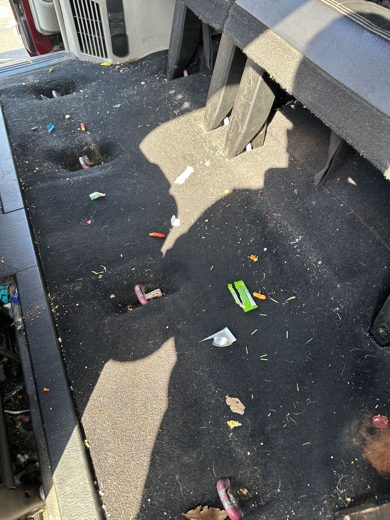 The bottom of a car with a lot of trash on it.