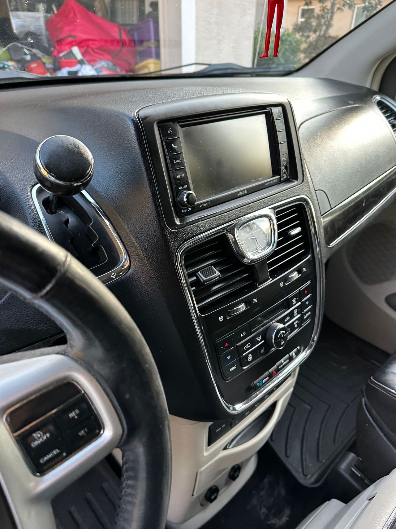 The interior of a dodge caravan with a steering wheel and a radio.