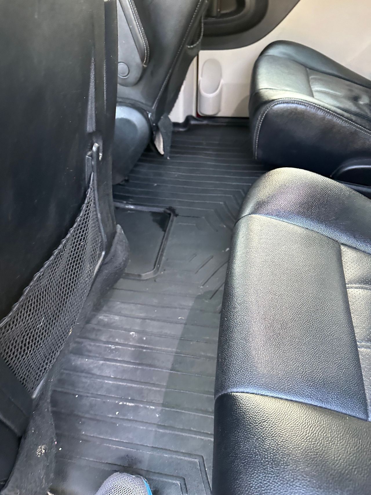 A person is standing in the back seat of a car.