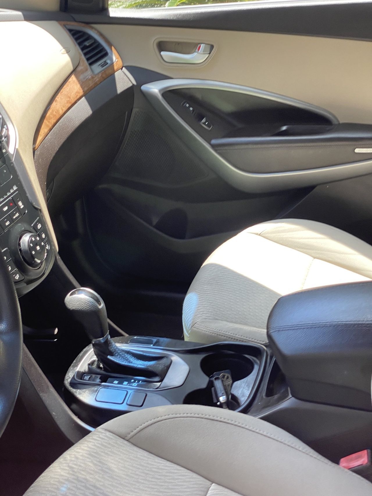 The inside of a car with a shifter and a cup holder