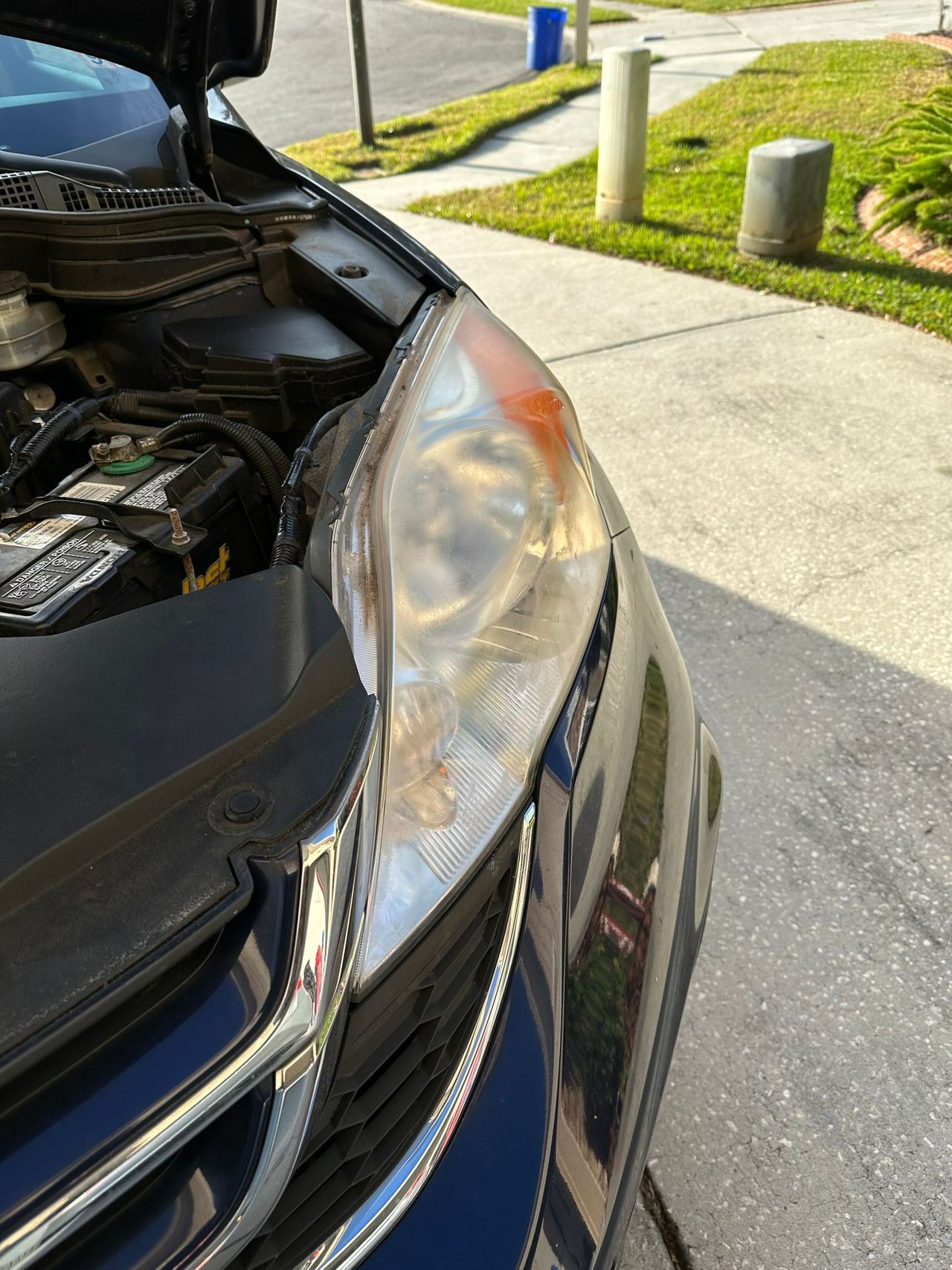 A car with the hood up is parked on the side of the road