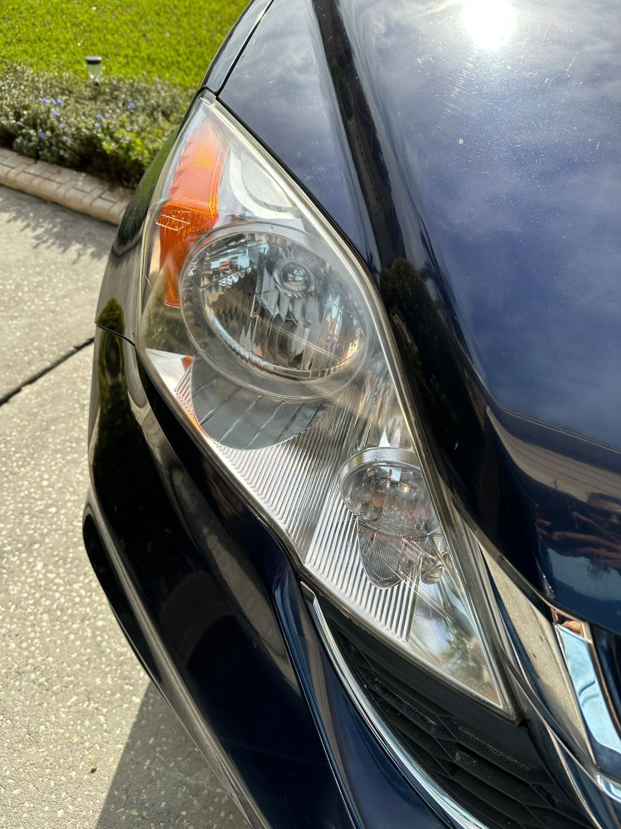 A close up of a car 's headlight on a sunny day.