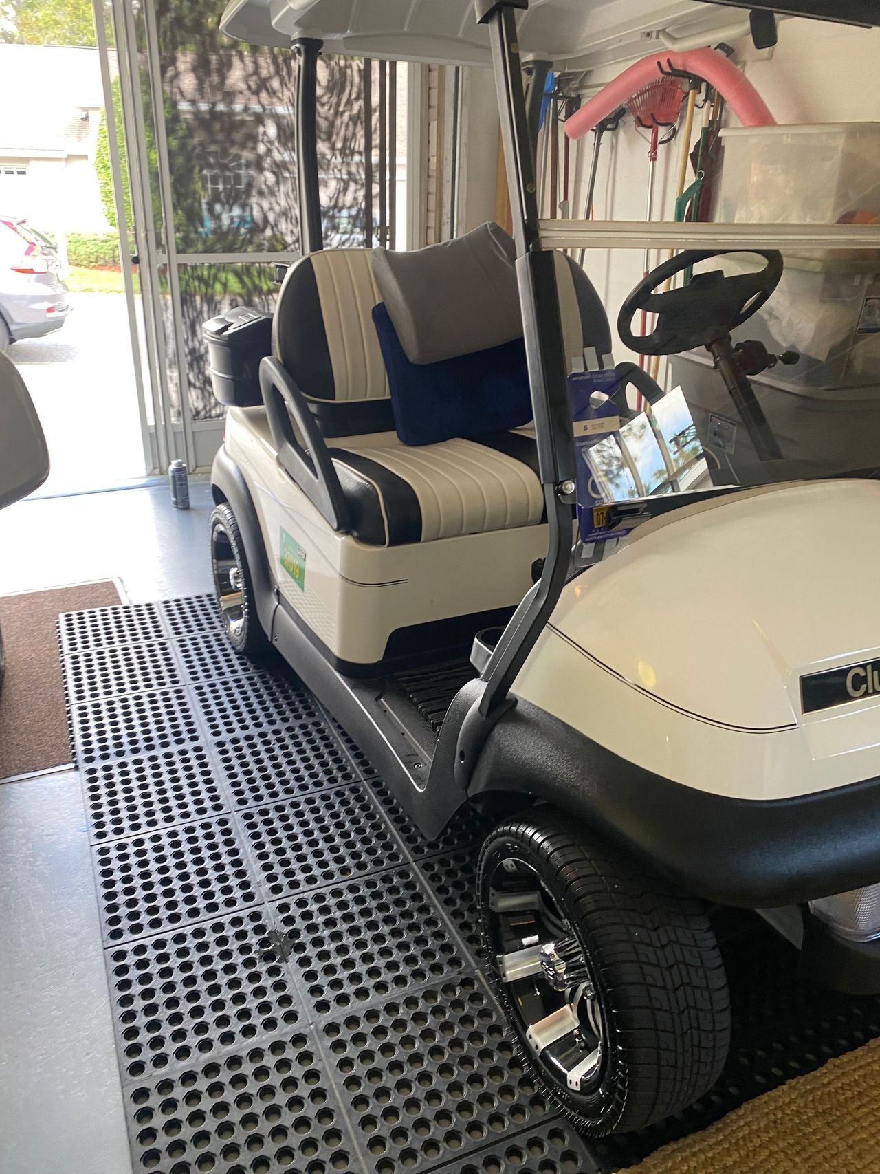 A white golf cart is parked in a garage.