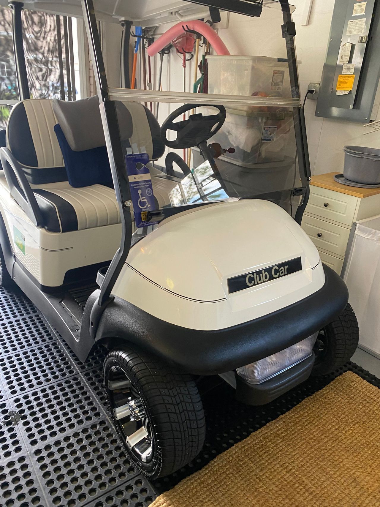 A white golf cart is parked in a garage.