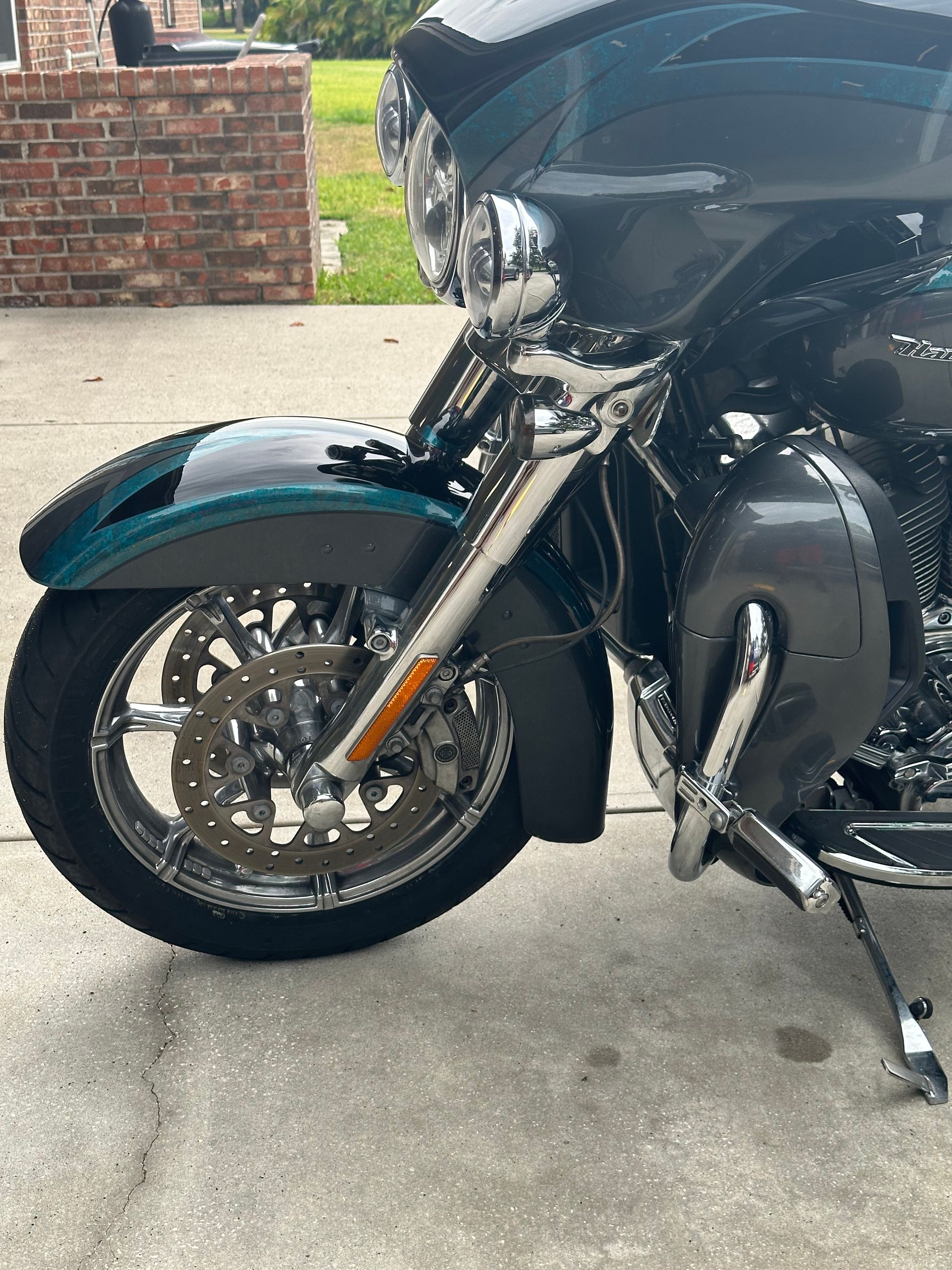 A motorcycle is parked on a sidewalk in front of a brick building.
