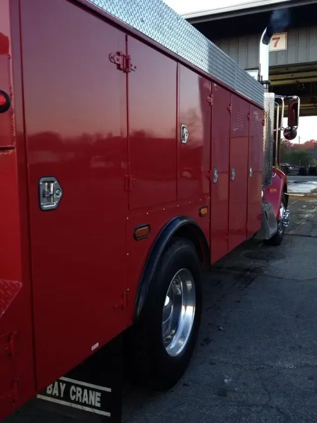 A red crane truck is parked in front of a building