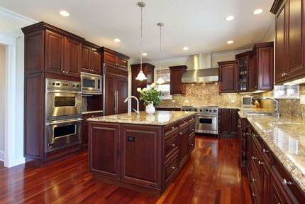 Luxurious kitchen with dark wood cabinets, stainless steel appliances, and granite countertops.