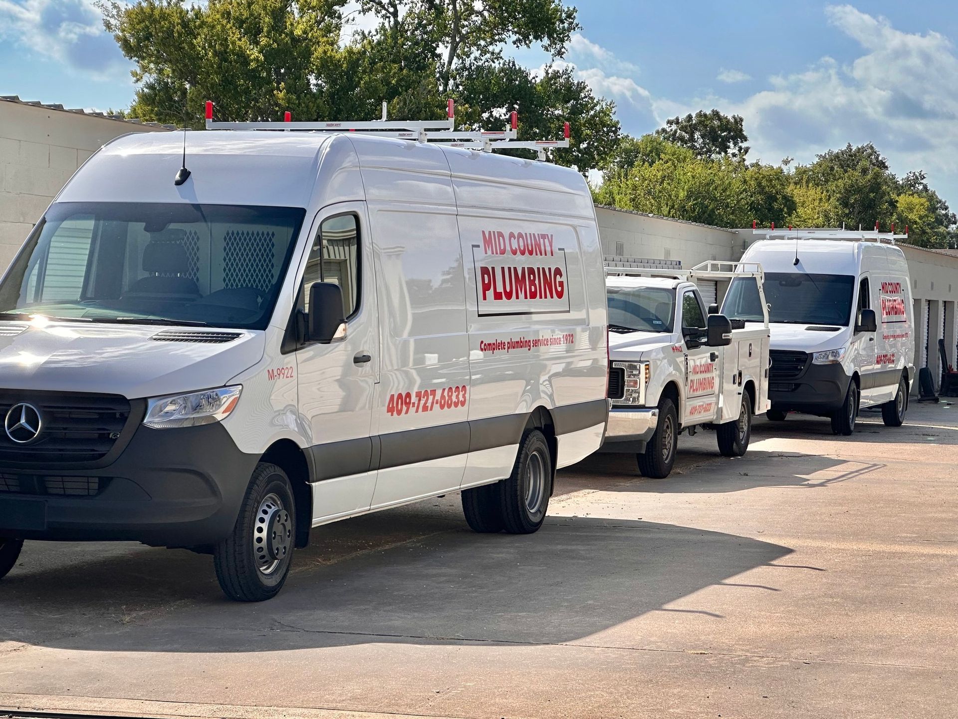 A row of white vans parked in a parking lot.