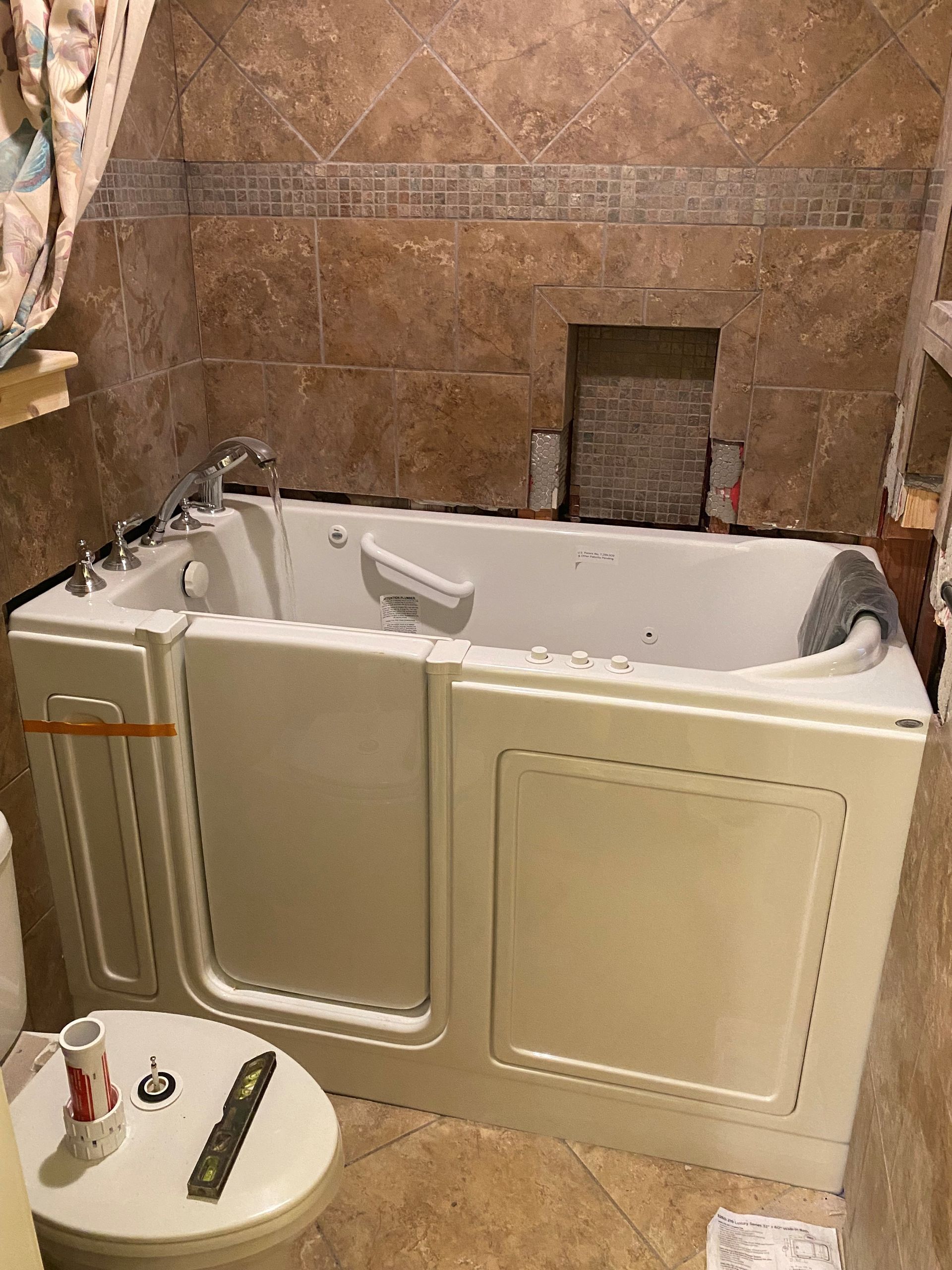 A walk in tub is in a bathroom next to a toilet.