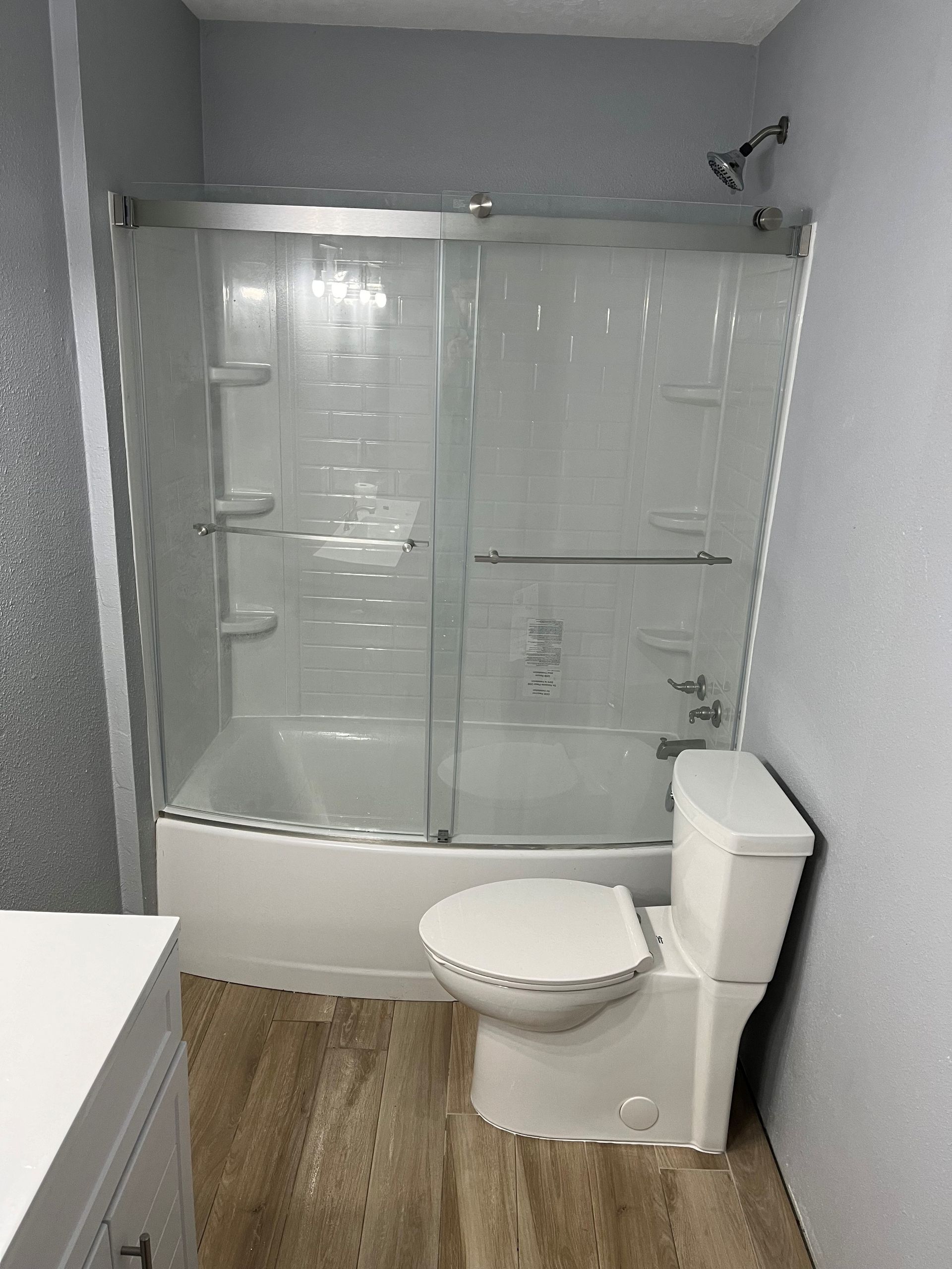 A bathroom with a toilet , tub and shower.