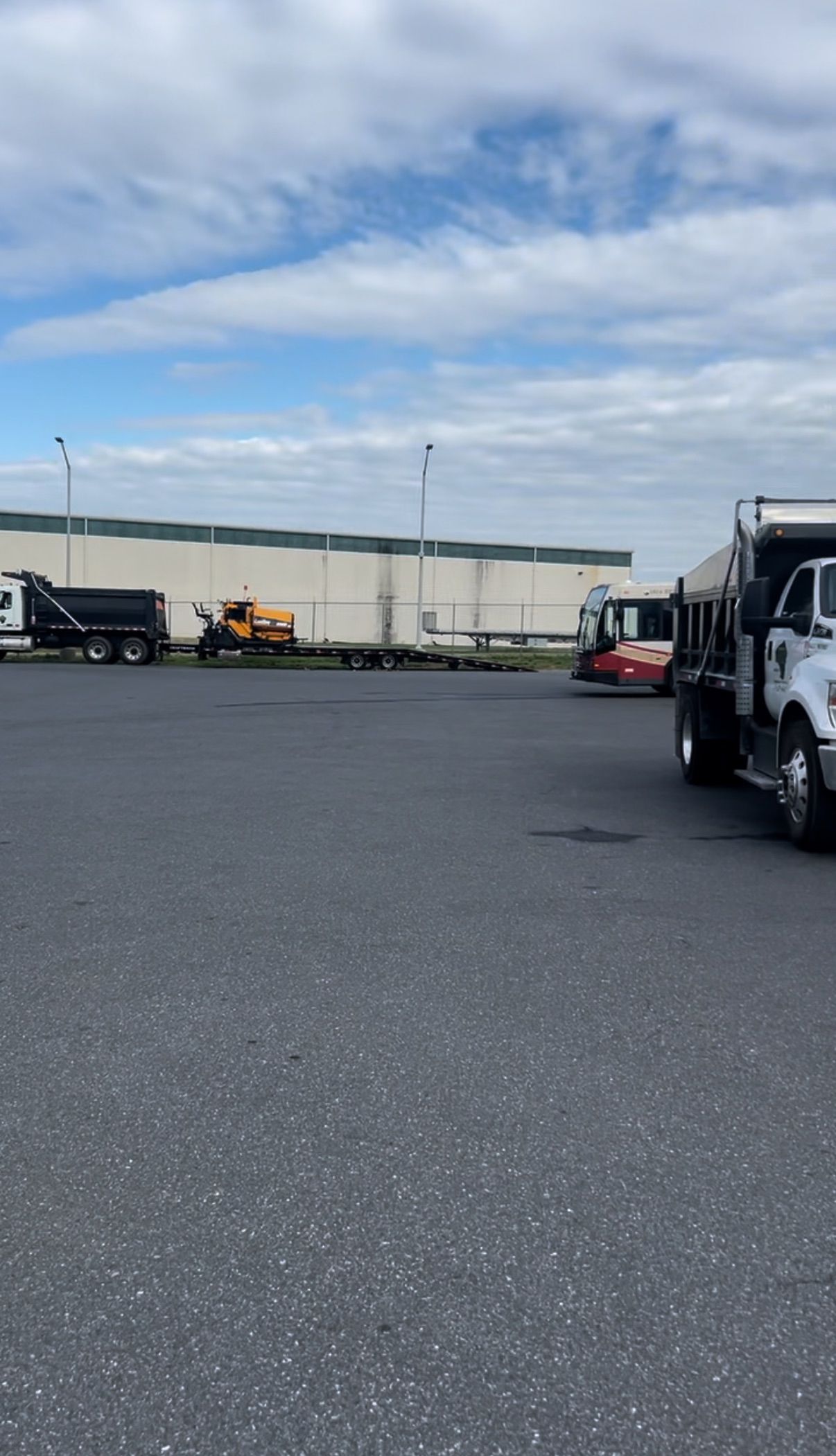 A lot of trucks are parked in a parking lot in front of a building.