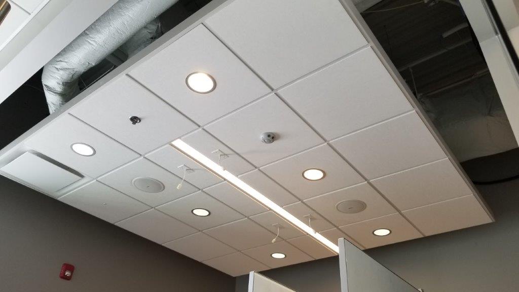 A ceiling with a lot of lights and speakers on it.