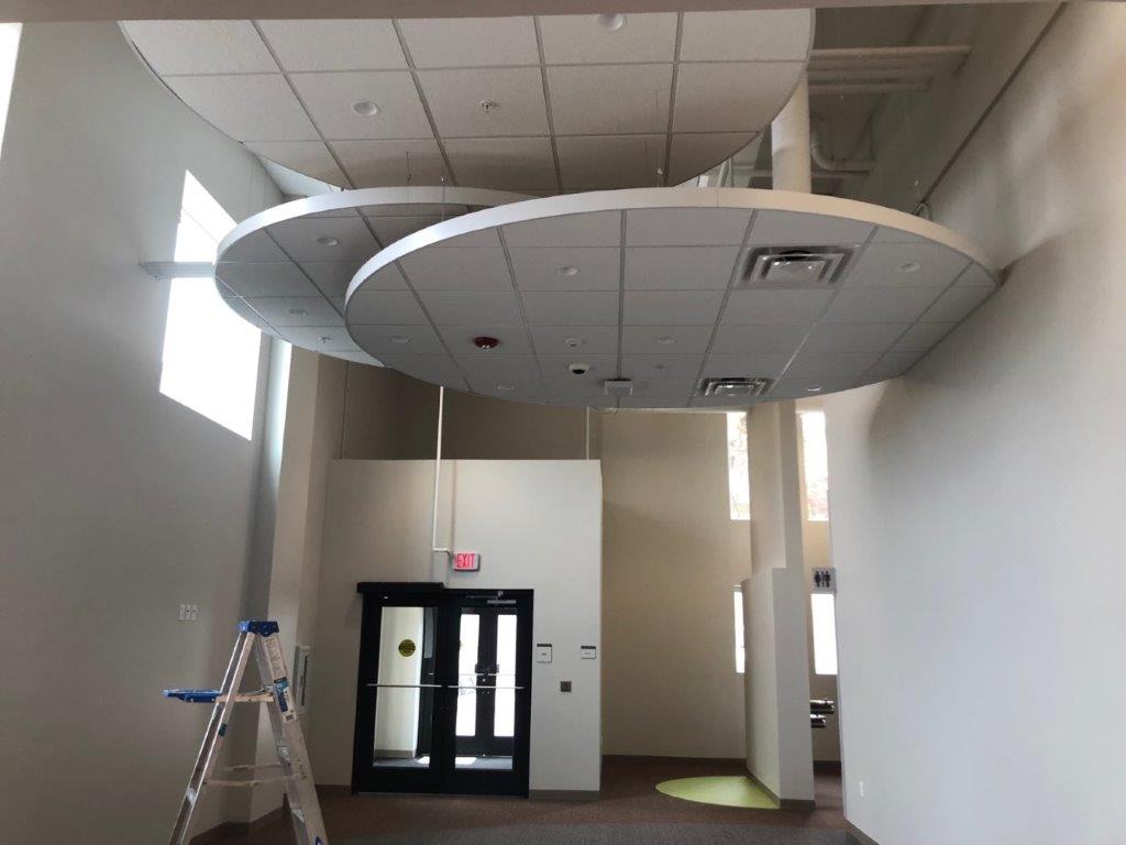A room with a ladder and a ceiling that looks like a ufo.